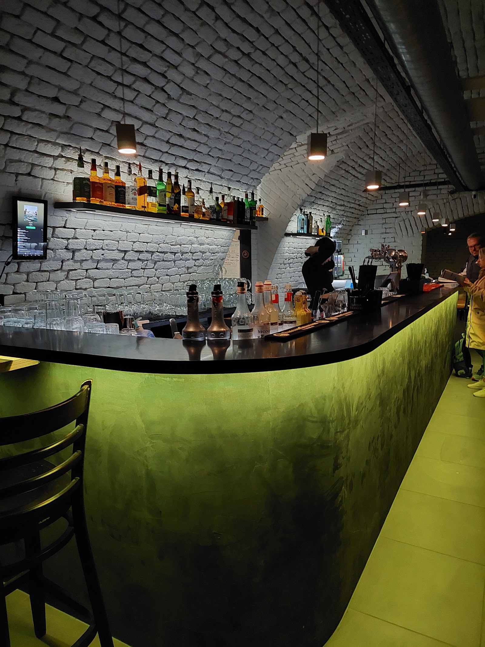Stylový bar s klenutým stropem a zeleným podsvícením